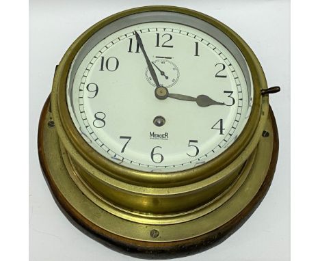 A brass ship's bulkhead wall clock, the 7 inch enamel dial with black Arabic numerals signed 'MERCER ST ALBANS, ENGLAND', the