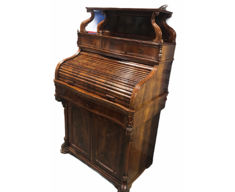 A good Victorian ladies tambour writing cabinet of serpentine form, the raised top with open shelf and foliate scroll carved 