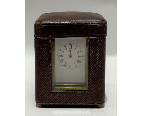 A miniature brass cased carriage timepiece with Moroccan leather fitted travel case, the 1.25in white enamel dial with black 