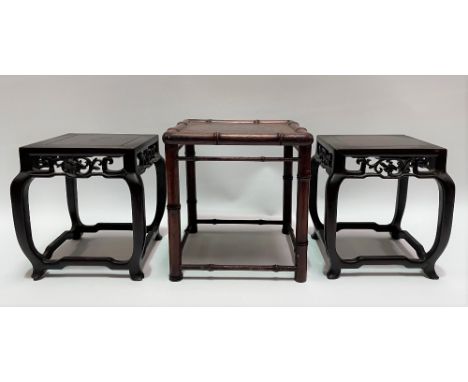 A pair of Chinese square section hardwood vase stands with foliate scroll carved frieze upon four shaped legs united by stret