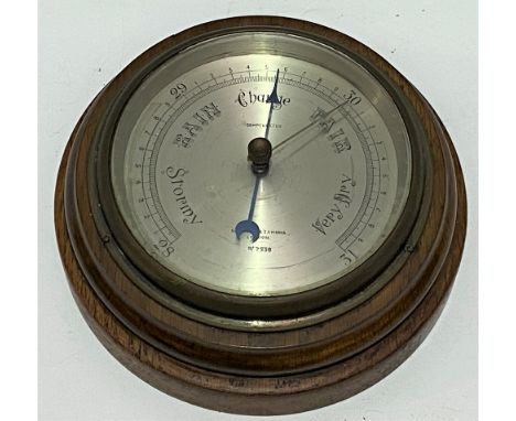 An aneroid barometer by Negretti &amp; Zambra London, with 4.5 inch silvered dial within oak case. 