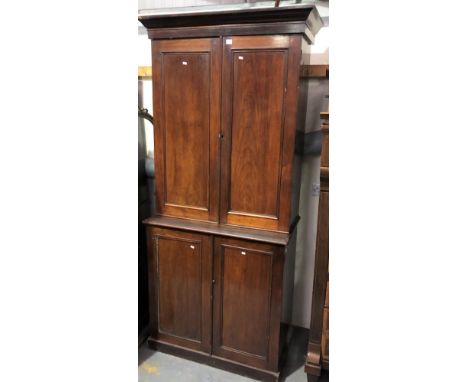 19th Century mahogany two-section estate cupboard, the pair of doors enclosing pigeonholes and three small drawers, the base 