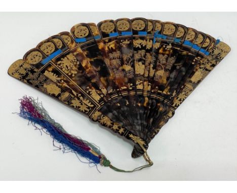 19th Century Chinese export gilt painted fan, the solid leaves decorated with seated figures under foliage, the guards decora