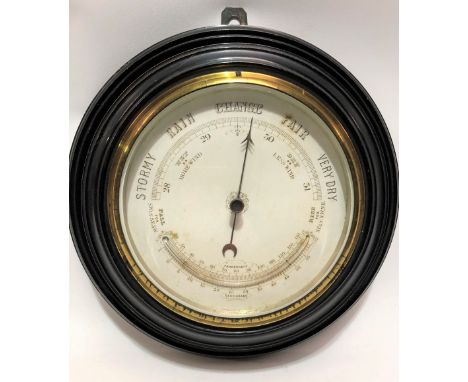 Aneroid barometer thermometer with 5.5in dial and within turned ebony frame, diameter overall 28cm