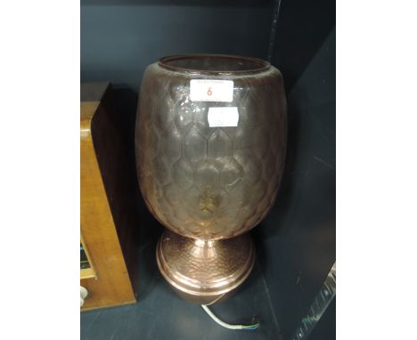 A copper oil lamp with glass shade