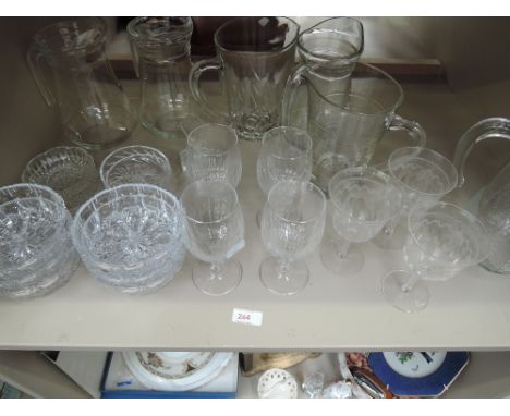 A shelf of glassware including wine glasses and jugs