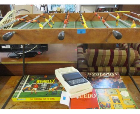 A vintage Italian Arcofalc football table with a red shirt team and a yellow shirt team, together with vintage board games to