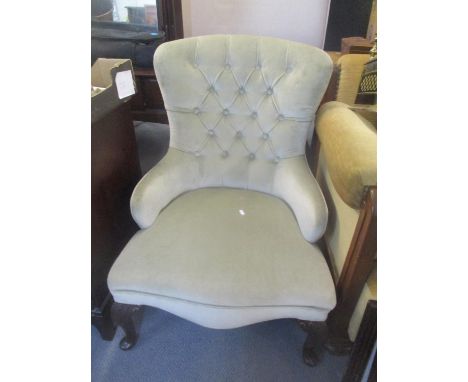 A reproduction button back low armchair on two front cabriole legs 