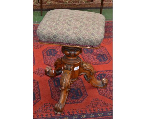 A Victorian carved walnut piano stool scrolling tripod base, c.1870