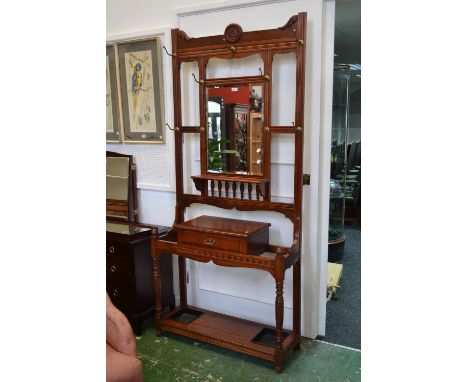 A magohany hall stand, rectangular bevel edge mirror and shelf over glove drawer, turned uprights