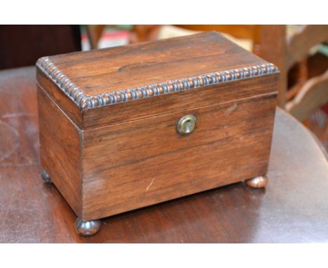 A George IV rosewood tea caddy, hinged cover with gadrooned border enclosing a pair of lidded compartments, bun feet, c.1830