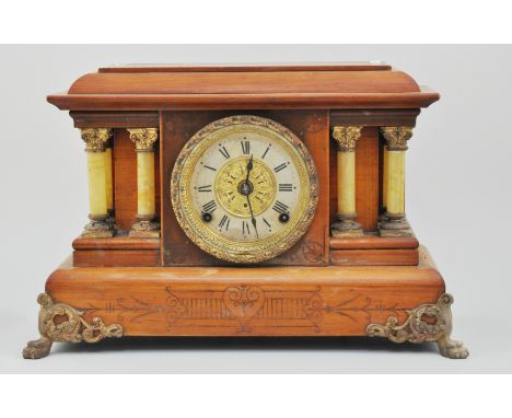 Stained wood mantle clock, with a brass dial, by Seth Thomas, mounted on brass feet, the dial flanked by pillars, height 30cm