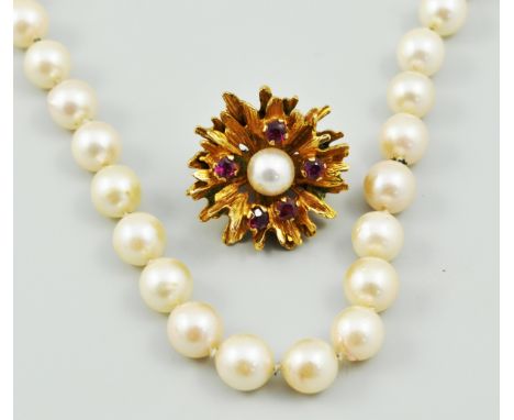 Lady's pearl necklace, with a 9ct gold flower head clasp, set with four ruby coloured stones with a centre pearl.