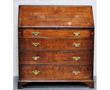 George III slope and fall front oak bureau, bracket feet, four long drawers with brass handles, the fall front enclosing a we