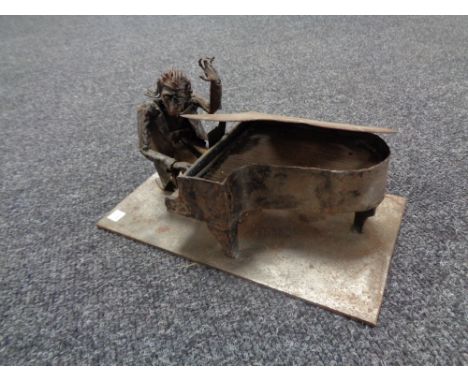 A metal figure of a man playing piano 