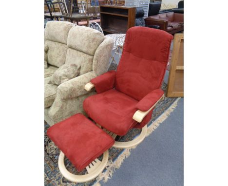 A contemporary beech framed red upholstered swivel relaxer armchair with stool 