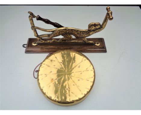 An early twentieth century dinner gong and beater on wall bracket modelled as a monkey 