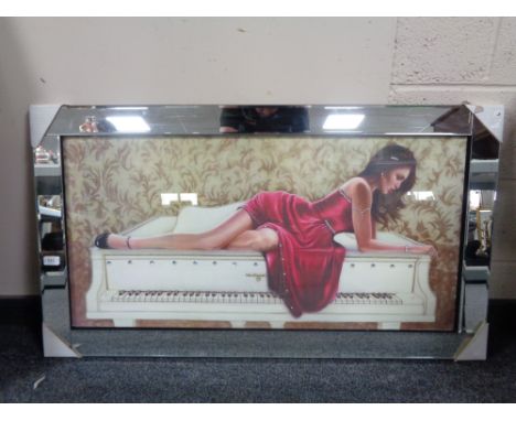 A framed print of a lady in red dress reclining on grand piano with glitter decoration in mirrored frame 