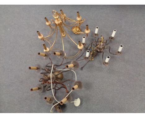 A decorative brass eight way light fitting together with two further copper light fittings. 