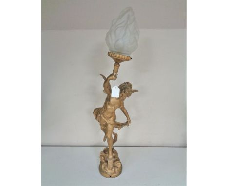 An antique painted spelter table lamp with shade modelled as a winged boy bearing a torch 