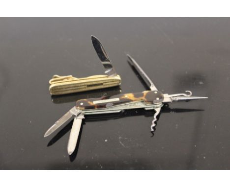 A NOVELTY MINIATURE PEN KNIFE IN THE FORM OF A TIE CLIP TOGETHER WITH A MINIATURE TORTOISE SHELL SIX TOOL PENKNIFE TO INCLUDE