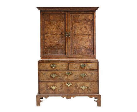 A walnut and feather banded cabinet,early 18th century and later, the stepped pediment over twin doors, enclosing a fitted in