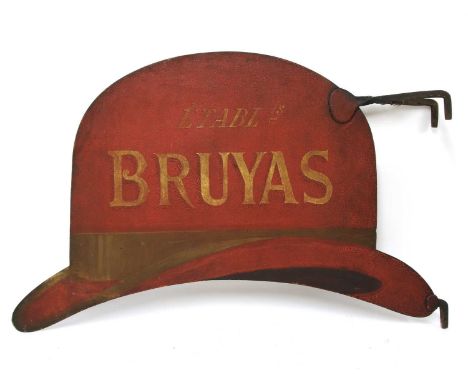 A red painted iron milliner's trade sign,late 19th century, in the form of a bowler hat, and inscribed 'Bruyas', on an iron b