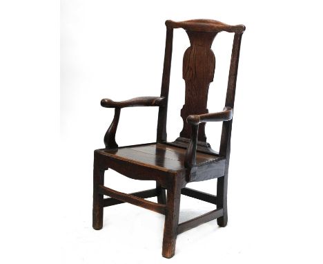 A substantial oak country open armchair,basically 18th century, with a shaped splat, curved arms and stretchered square suppo