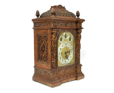 A musical bracket clock,late 19th/early 20th century, in a carved oak case, the arched dial with subsidiary dials for regulat