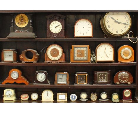 A collection of 26 assorted clocks including oak cased mantel clocks, a black-forest style wall clock and small travel clocks