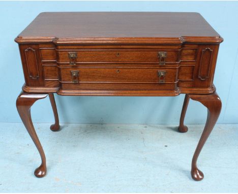 A mahogany canteen table with two long drawers and raised on cabriole supports enclosing a collection of Viner's 'Sandringham