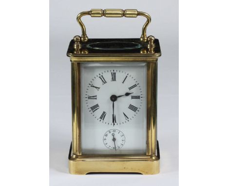 A brass carriage clock, the top with exposed platform escapement, the white enamel dial with Roman numerals denoting hours an