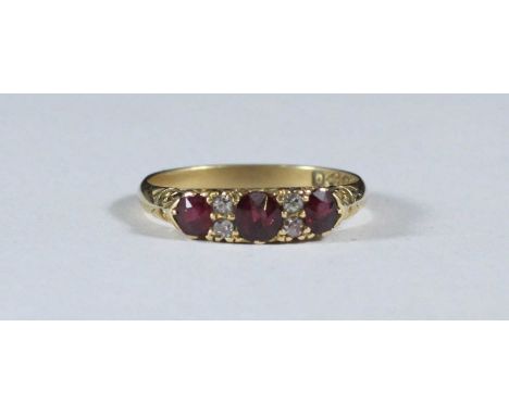 An 18ct gold ring, the top set with three ruby coloured stones and four small diamonds. Ring size 'O', gross weight approxima