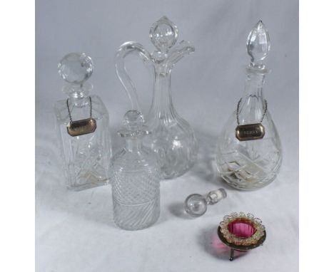 Four various cut glass decanters, two with silver bottle tags together with a cranberry glass candlestick and a spare stopper