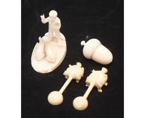 An ivory figure of a man with a sack of food facing two expectant rabbits, (one foot missing), together with two unusual ivor