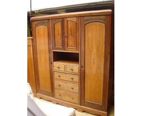  An Edwardian walnut triple compactum wardrobe, the lift off cornice above a central section with a cupboard over an open she