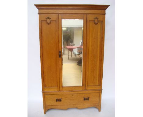 An Edwardian light oak single mirror door wardrobe, with detachable projecting cornice and long drawer to base. 