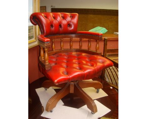 A red leather button back swivel desk chair. 