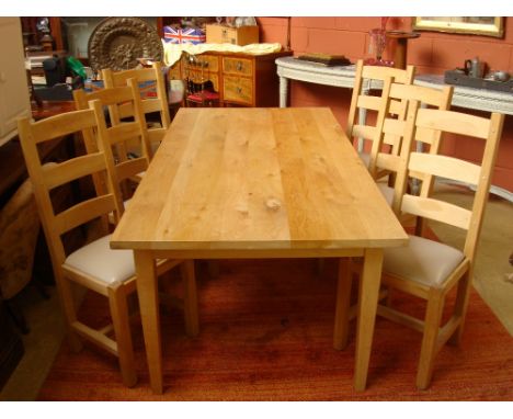 A modern light oak farmhouse table together with a set of six ladder back light oak chairs with drop in seats.
200 x 100 x 77