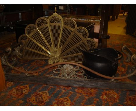 A Victorian brass fender together with a brass folding fan shaped fire screen and a helmet shaped coal scuttle. 