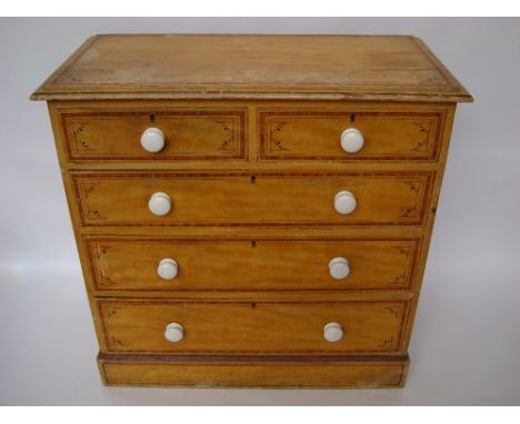 A late Victorian scumbled and painted pine chest of drawers, with two short and three graduated long drawers, with ceramic ha