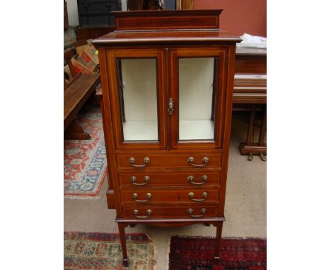 An Edwardian mahogany music cabinet inlaid with barbers pole stringing, upper glazed section with a pair of cupboard doors en