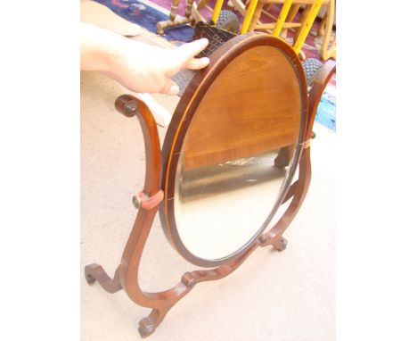 A late 19th Century George III style mahogany skeleton toilet mirror, with oval bevelled plate. 