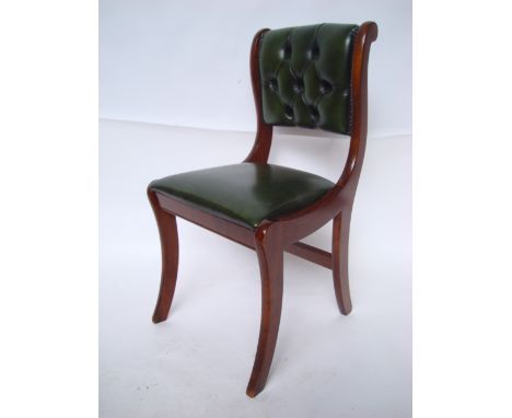 A reproduction mahogany Regency style chair, with green leather brass studded drop in seat and button back, on sabre legs.