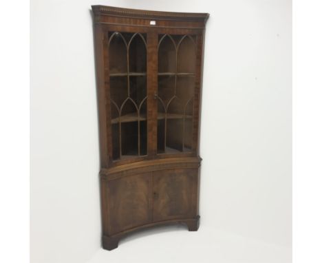 20th century figured mahogany double corner cabinet, dentil frieze above two doors enclosing two shelves above two cupboard d