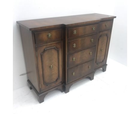 Small reproduction cross banded mahogany breakfront cabinet, two short and four long drawers, two cupboards, shaped bracket s