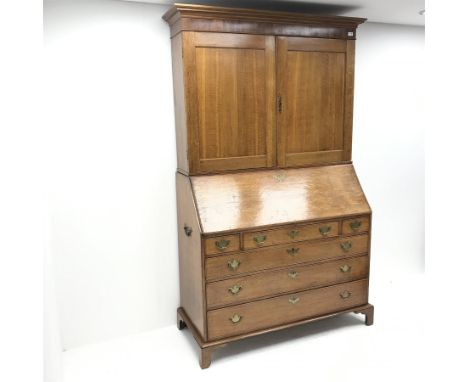 Georgian oak bureau bookcase, projecting cornice, two cupboards above fall front enclosing well fitted interior, six graduati