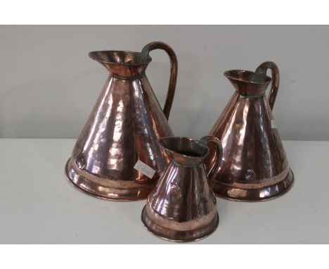 Three vintage graduated copper jugs largest is 26cm tall 