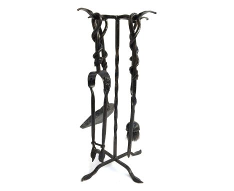 A set of wrought iron fire tools on stand, to include poker, tongs, brush and shovel 