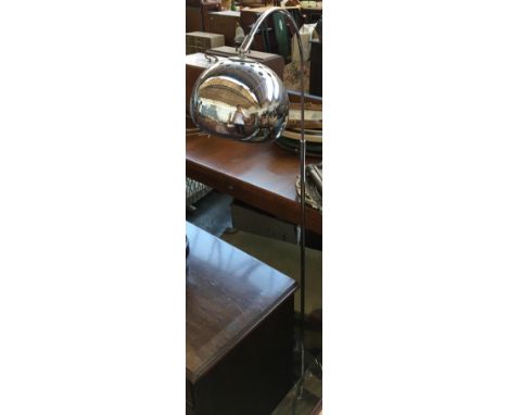 A chrome floor lamp with chrome shade 